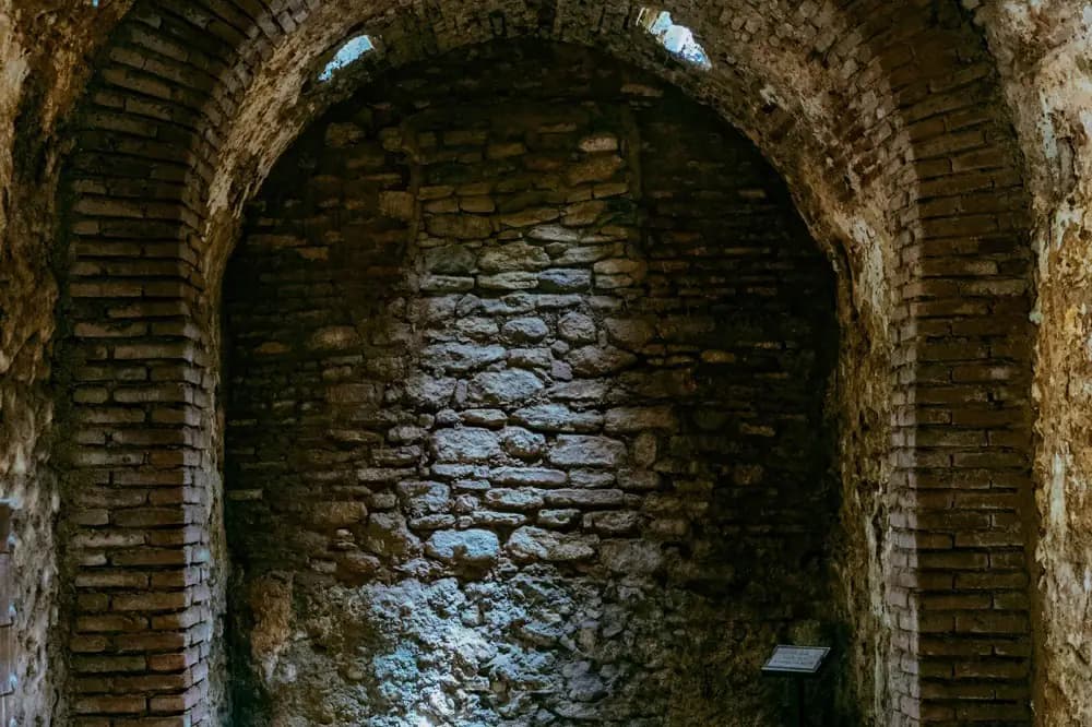 Galerie voûtée en brique et en pierre, éclairée au fond